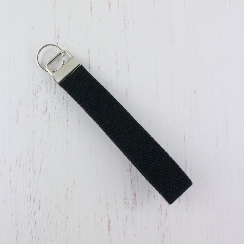 May include: A black canvas key chain with a silver key ring.
