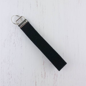 May include: A black key chain with a silver key ring and a silver clasp.
