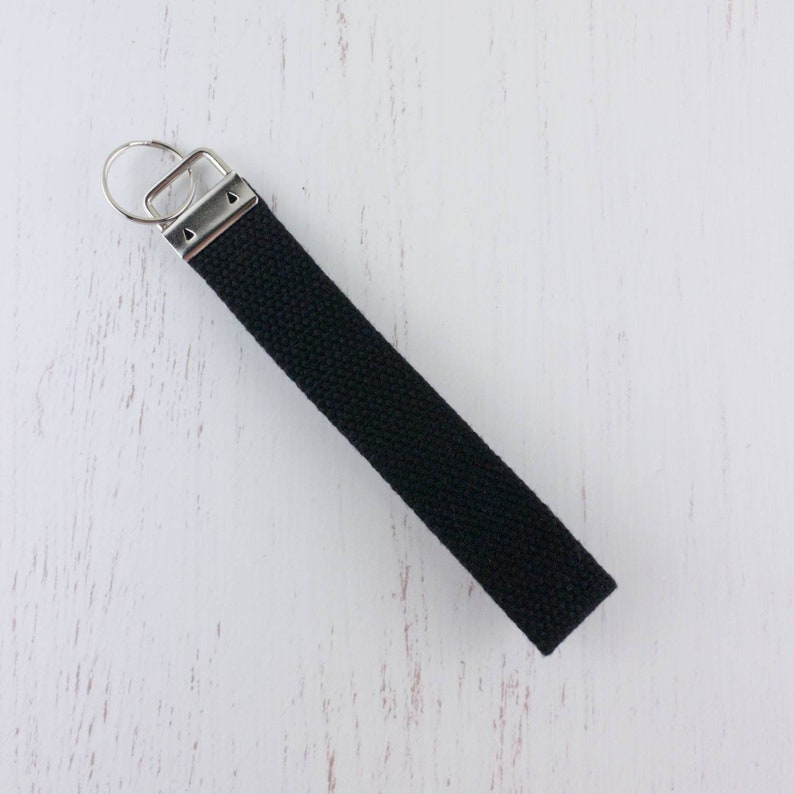 May include: A black key chain with a silver key ring and a silver clasp.