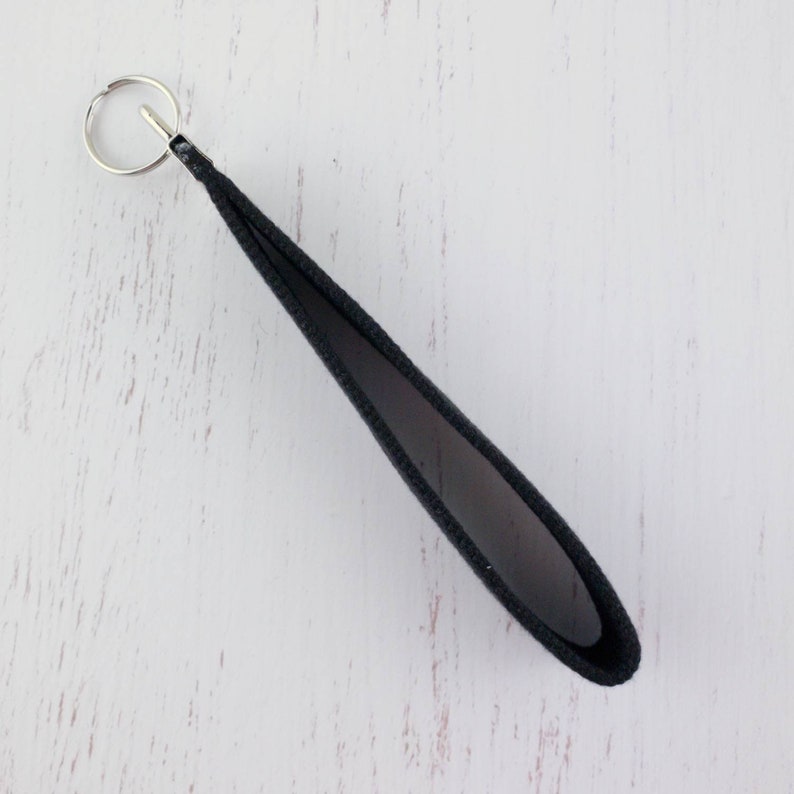 May include: A black fabric key chain with a silver metal key ring.