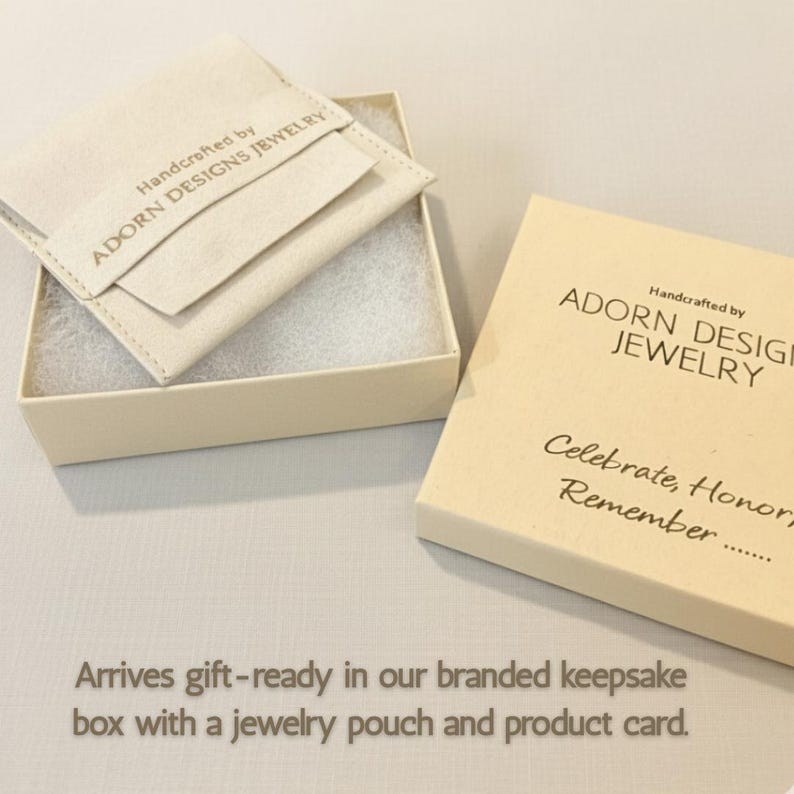 May include: A cream-colored gift box with the text "Handcrafted by ADORN DESIGNS JEWELRY" and "Celebrate, Honor, Remember..." printed on it. Inside the box is a jewelry pouch. The text "Arrives gift-ready in our branded keepsake box with a jewelry pouch and product card."