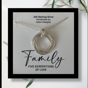 May include: A silver necklace with a five-ring pendant that says "Family Five Generations of Love". The necklace is made of .925 sterling silver and is handmade by Adorn-Designs.