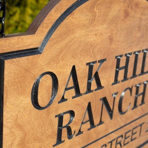 Close-up of engraved wooden ranch sign, personalized Baltic birch farm entrance sign with carved Oak Hill Ranch lettering and natural wood grain detail.