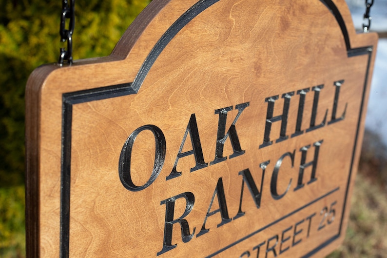 Close-up of engraved wooden ranch sign, personalized Baltic birch farm entrance sign with carved Oak Hill Ranch lettering and natural wood grain detail.