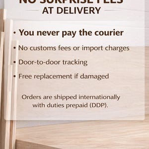 May include: A light-colored wooden surface with a white rectangular sign. The sign has the text "NO SURPRISE FEES AT DELIVERY" and bullet points detailing benefits like no courier payments, no customs fees, door-to-door tracking, and free replacements.