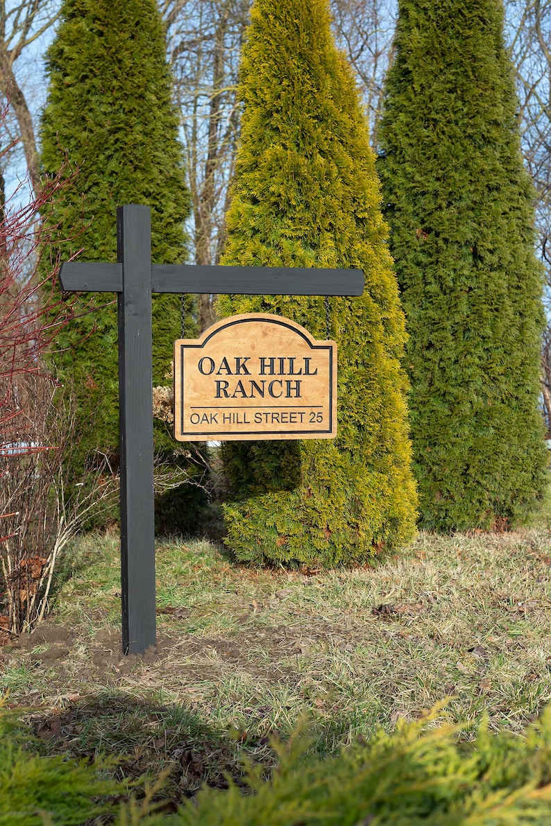 Custom wooden ranch sign for farm entrance, personalized Baltic birch property sign hanging on black post with engraved Oak Hill Ranch text, outdoor farmhouse driveway sign.