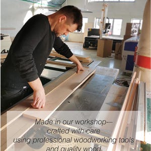 May include: A person working with wood in a workshop. The image shows a person working with wood, using professional woodworking tools. The text in the image reads: Made in our workshop--crafted with care using professional woodworking tools and quality wood.