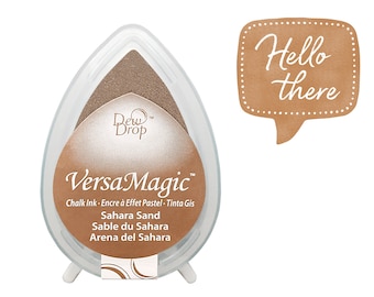 Puede incluir: Una almohadilla de tinta de tiza VersaMagic de color arena con el texto "Sahara Sand" y "Dew Drop" en blanco. La almohadilla de tinta está en un recipiente de plástico transparente con forma de lágrima. El texto "Hello there" está escrito en un bocadillo de diálogo.