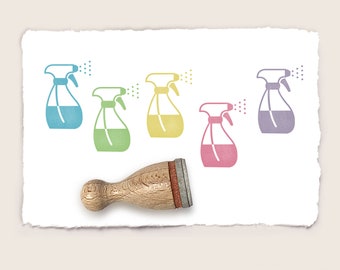 Puede incluir: Un conjunto de cinco sellos de goma de colores con un diseño de botella de spray. Los sellos están dispuestos en una fila sobre un fondo blanco. Los sellos son azules, verdes, amarillos, rosas y morados. También se muestra un mango de sello de madera en la imagen.