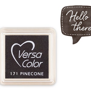 Könnte beinhalten: Ein schwarzes Stempelkissen mit einem weißen Herzen und dem Text "Versa Color" und "171 PINECONE".