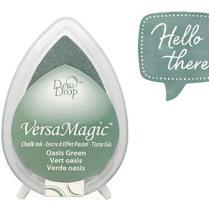 May include: A white, teardrop-shaped ink pad with a green ink surface. The ink pad is labeled "VersaMagic Oasis Green" and includes text in French and Spanish. A teal speech bubble with the words "Hello there" is also present.