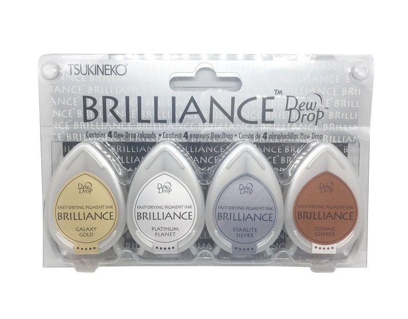 May include: A set of four Tsukineko Dew Drop Brilliance fast-drying pigment ink pads in the colours Galaxy Gold, Platinum Planet, Starlite Silver, and Cosmic Copper.