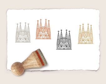 May include: Four different coloured rubber stamps of a church building with a cross on top. The stamps are on a white piece of paper with a wooden handle stamp next to them.