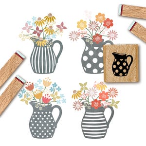 May include: A set of four wooden rubber stamps featuring illustrations of pitchers filled with various colorful flowers. The designs include pitchers with vertical stripes, horizontal stripes, and polka dots, alongside a single square stamp.