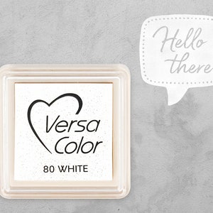 May include: White ink pad with a heart and the text "Versa Color 80 WHITE" in black. The ink pad is in a clear plastic case.