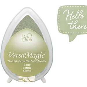 May include: A sage green VersaMagic Dew Drop chalk ink pad in a clear plastic teardrop-shaped container. The ink pad is next to a light green speech bubble with the words "Hello there" in white script.