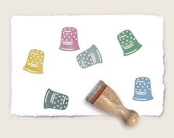 May include: Six colorful thimble rubber stamps with white polka dots on a white background. A wooden stamp handle is also shown.