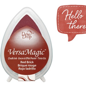 May include: Red brick colored ink pad with the words "Dew Drop" and "VersaMagic" in white. The ink pad is labeled "Chalk Ink - Encre à Effet Pastel - Tinta Gis" and "Red Brick - Brique rouge - Rojo ladrillo".