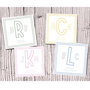 Op de afbeelding: Vier vierkante kaarten met monogram initialen in pastelkleuren: groen, geel, roze en blauw. Elke kaart heeft een witte achtergrond, een gekleurde rand en de tekst "WITH LOVE" en een naam.