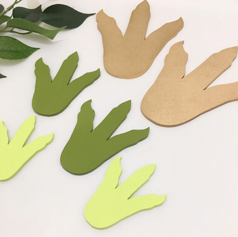 May include: Five dinosaur footprints cut from craft paper. Two are green, two are light green, and one is brown.