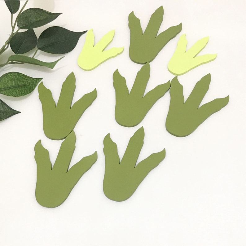 May include: Set of nine green and yellow dinosaur footprints. The footprints are made of felt and are perfect for a dinosaur-themed party or craft project.