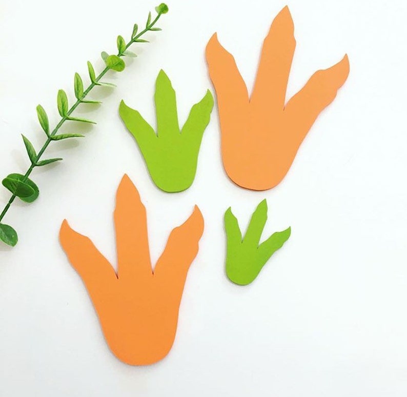 May include: Four dinosaur footprints cut out of paper. Two are orange and two are green.