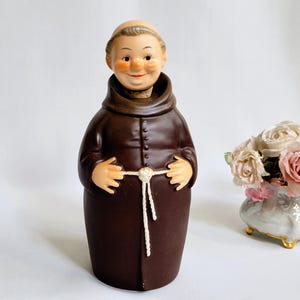 Puede incluir: Un juego de tres tazas de cerámica con acabado mate moteado. Las tazas son de color crema, gris claro y gris oscuro. Cada taza tiene un diseño simple y minimalista.