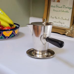 May include: A set of three ceramic mugs with a speckled, matte finish. The mugs are in shades of cream, light gray, and dark gray. Each mug has a simple, minimalist design, perfect for coffee or tea.