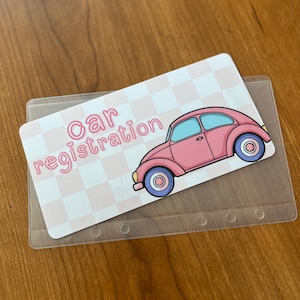 May include: A pink car with a blue windshield and white wheels on a pink and white checkered background. The text "car registration" is written in pink letters with a heart symbol.