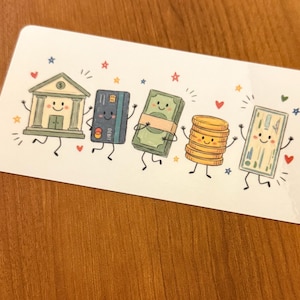 May include: A rectangular white card featuring a colorful cartoon illustration of five anthropomorphic financial icons: a bank building, a blue debit card, a stack of green paper money, a stack of gold coins, and a single green bill, all with smiling faces.