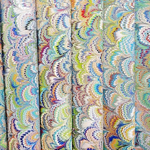 May include: A collection of six vertical panels featuring a marbled paper pattern with a repeating fan-like design. The intricate swirls display a vibrant palette of blue, green, yellow, red, and white colors, creating a dense, layered texture.