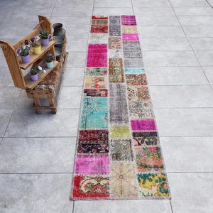 Pode incluir: Um tapete comprido e retangular de patchwork com uma variedade de cores e padrões. O tapete é feito de diferentes pedaços de tecido costurados juntos, criando um design único e eclético. O tapete é perfeito para adicionar um toque de cor e personalidade a qualquer cômodo.