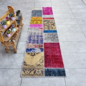 May include: A colorful patchwork runner rug with a variety of colors and patterns, including blue, red, yellow, and pink. The rug is made of recycled materials and has a unique, handmade look.