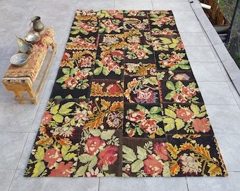 May include: A colorful patchwork rug with floral designs in shades of red, yellow, green, and brown. The rug is made of woven fabric and has a distressed look.