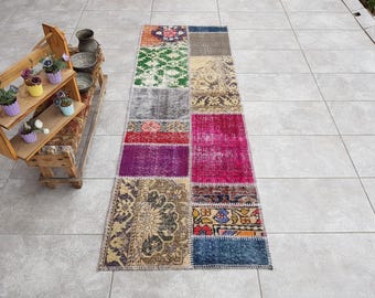 Puede incluir: Un corredor de patchwork colorido con una variedad de patrones y colores, incluyendo rosa, morado, azul, verde y marrón. La alfombra está hecha de materiales reciclados y tiene un aspecto desgastado.