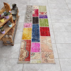 Könnte beinhalten: Ein bunter Patchwork-Teppich mit verschiedenen Farben und Mustern, darunter Rot, Blau, Grün, Gelb und Pink. Der Teppich ist aus recycelten Materialien hergestellt und hat einen Used-Look.