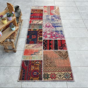 Peut inclure: Un tapis patchwork coloré avec une variété de motifs et de couleurs, notamment le rouge, le bleu, le vert et le marron. Le tapis est fait de matériaux recyclés et a un aspect unique et fait main.
