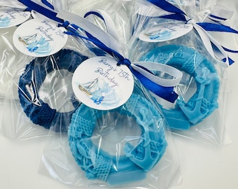 May include: Blue and white favor bags with blue and white nautical themed soap favors. The bags are tied with blue and white ribbon and have a tag that says "Barry's 75th Birthday".