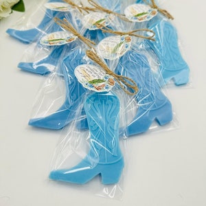 Könnte beinhalten: Blaue Cowboy-Stiefel-Seifen-Geschenke, verpackt in durchsichtigen Cellophanbeuteln mit Schnur und einem kleinen Etikett mit der Aufschrift "Vielen Dank, dass Sie mit uns feiern Cowboy Up!"