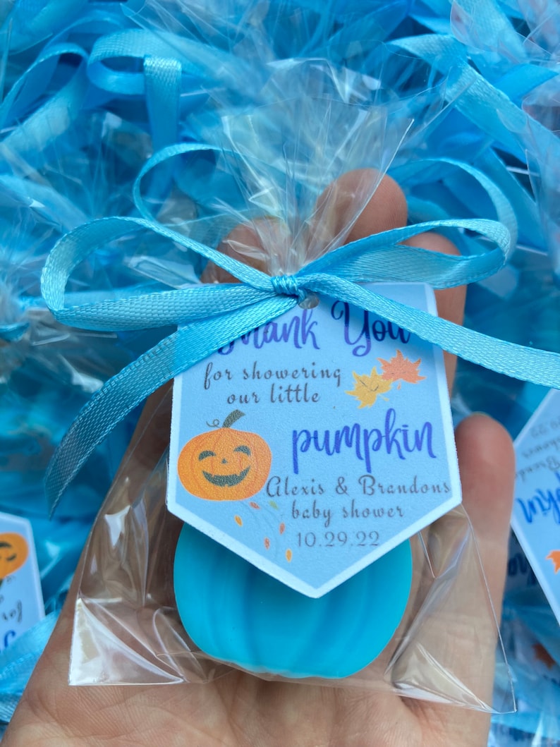 May include: Blue pumpkin shaped soap favors with a thank you tag that reads "Thank You for showering our little pumpkin Alexis & Brandons baby shower 10.29.22".