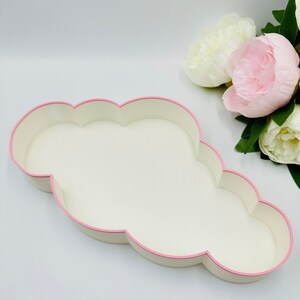 May include: A white cloud-shaped tray with a pink trim. The tray is made of a smooth, textured material.