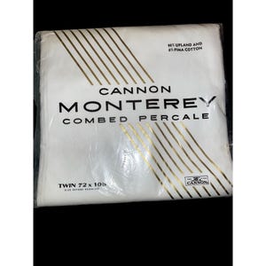 May include: A packaged white Cannon Monterey combed percale twin sheet set. The packaging features gold diagonal stripes and text that reads "94% Upland and 6% Pima Cotton". The dimensions are 72 x 108 inches.