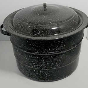 May include: A large, black speckled preserving pot with a matching lid. The pot has two side handles and a lid handle. The pot is designed for preserving food and has a wide rim. The exterior is black with white speckles.
