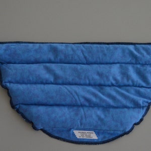 May include: Blue quilted neck wrap with a dark blue trim. The wrap has a long strap that can be tied around the neck.