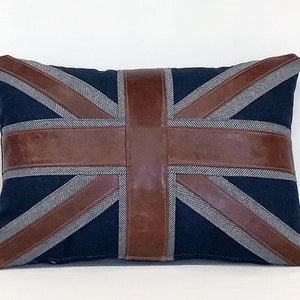 May include: A blue and brown throw pillow with a Union Jack design. The pillow is made of fabric with a leather-like material for the Union Jack design.