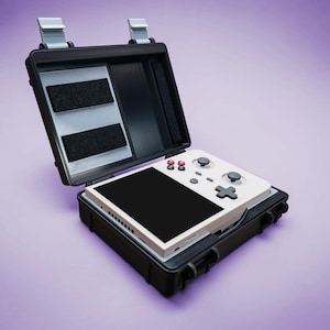 May include: A black, open carrying case with a white handheld gaming device inside. The device has a black screen, red and white buttons, and a directional pad. The case has two latches and a purple background.