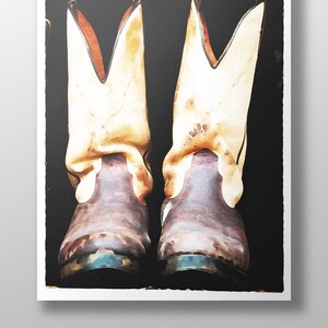 May include: A pair of brown leather cowboy boots with white tops and stitching. The boots are set against a black background.