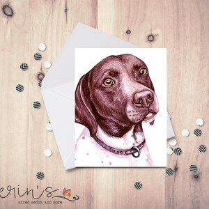 May include: A watercolor greeting card featuring a German Shorthaired Pointer dog. The dog has brown and white fur, with a brown collar. The card is inside a white envelope, with confetti scattered around it. The artist's signature is at the bottom.