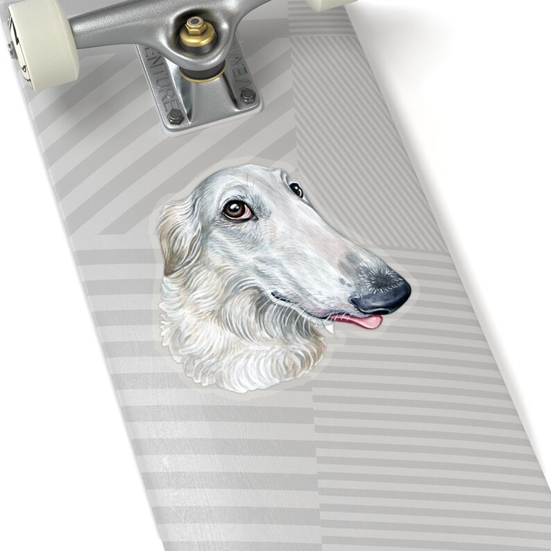 May include: A white Borzoi dog with brown eyes and a pink tongue sticking out. The dog is looking to the right of the image. The dog is on a gray and white striped background.