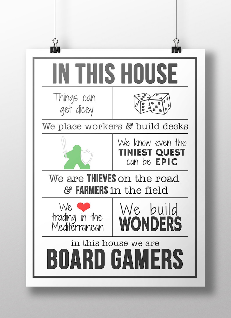 May include: A white poster with black text that reads "In this house we are board gamers". The poster has a grid of images and text describing different aspects of board games, including dice, workers, quests, thieves, farmers, trading, and wonders.